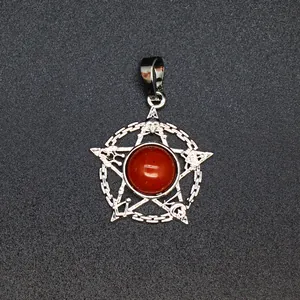 Gedetailleerde opname van een zilveren pentagram hanger met een rode steen en symbolen