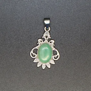 Close-up detail of a silver-toned filigree pendant with an oval green natural stone