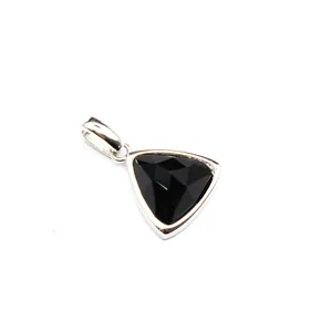 Macro detail view of a small faceted black crystal triangle pendant with a silver bail.
