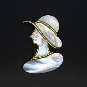 Détail d'une broche élégante en nacre naturelle représentant une silhouette de dame