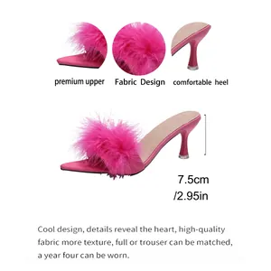 Dettaglio delle sabot rosa acceso con piume soffici e un tacco sottile alto 7,5 cm.