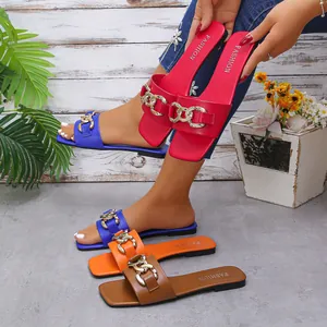 Detailed view of colorful square toe flat sandals with gold chain decorative straps
