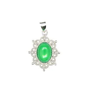 Detail showing a vintage green stone pendant with ornate silver filigree metal frame