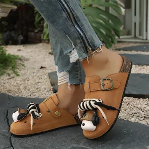 Close-up of brown suede platform clogs featuring a cute cartoon dog and rope detail
