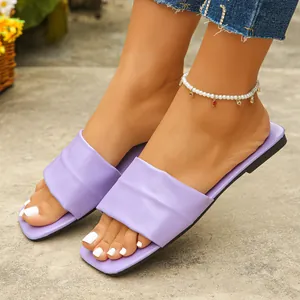 Close-up of lavender square-toe flat slides for women in an outdoor setting
