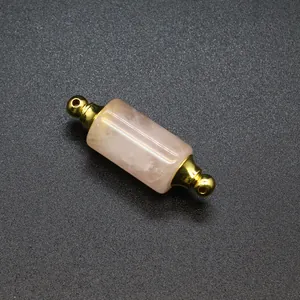 Close-up of rose quartz cylindrical essential oil bottle pendant with gold caps