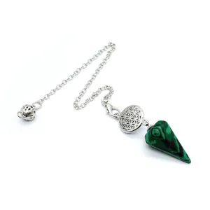 Gros plan d'un pendule en malachite verte avec un détail de fleur de vie en argent