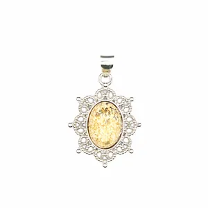 Macro view of vintage silver-tone pendant with oval natural stone and lace frame