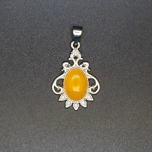 Detailed view of vintage silver pendant featuring yellow oval stone and crystal accents.