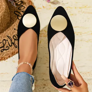 Elegantes zapatos planos negros de punta con una gran hebilla de metal dorado detalle