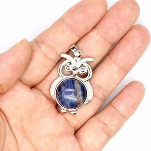 Vista dettagliata di un piccolo ciondolo a forma di gufo con pietra di sodalite blu.