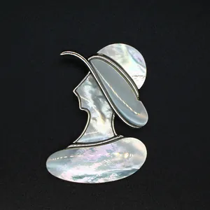 Détail rapproché d'une broche vintage silhouette de dame en nacre naturelle irisée