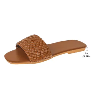 Detail view showing the 1cm heel height of the brown woven flat sandals.