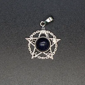 Detailopname van een zilveren pentagram hanger met een sprankelend blauw zandsteen inlegwerk