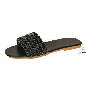 Close-up detail showing the 1cm flat heel measurement of black woven strap slide sandals