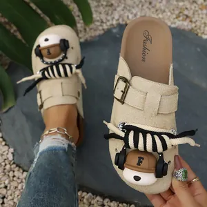 Detail of beige thick-soled clogs with cute bear decoration and rope ties