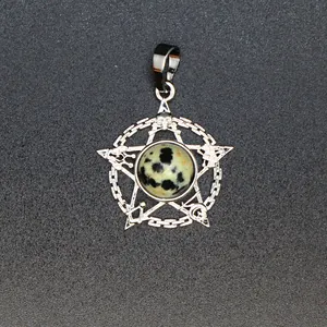 Detailopname van een zilveren pentagram hanger met een gespikkelde dalmatiër jaspis steen