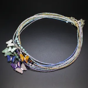 Detailed view of multi-strand beaded necklace with natural stone butterfly charms.