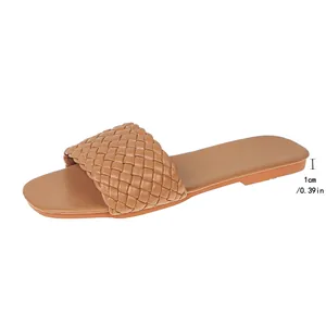 Close-up of tan woven flat slide sandal with 1cm heel height detail