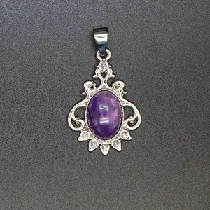 Detailed macro view of a vintage silver-toned pendant with oval purple amethyst stone