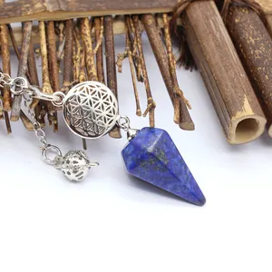 Gros plan détaillé sur un pendule hexagonal en lapis-lazuli et motif floral argenté