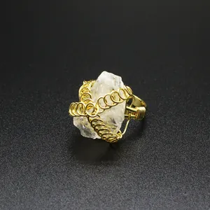 Dettaglio macro che mostra l'intricato design in filo d'oro su un anello di cristallo grezzo