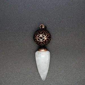 Dettaglio macro di un ciondolo a cono in cristallo bianco con una sfera di bronzo
