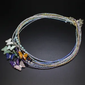 Macro detail of multi-layer beaded necklace with colorful stone butterfly pendants