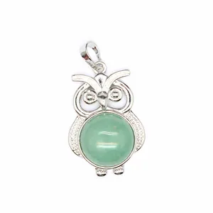 Primo piano del ciondolo a forma di gufo in argento con cristallo verde.