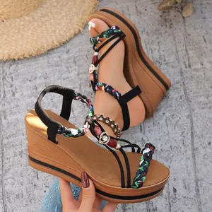 Sandales compensées bohèmes avec brides tressées colorées et perles sur plateforme.