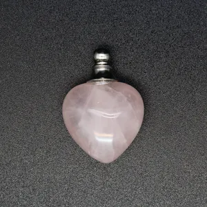 Dettaglio macro di un ciondolo bottiglia di profumo in quarzo rosa a forma di cuore