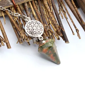 Détail exquis d'un pendule en unakite avec un charme d'argent de la fleur de vie