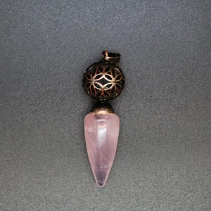 Dettaglio del pendente in quarzo rosa a cono con sfera in metallo traforato anticato.