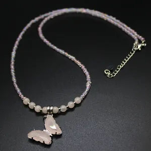 Detail shot of an elegant pink butterfly pendant on an iridescent beaded crystal necklace