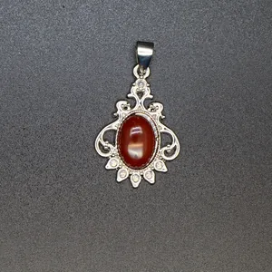 Vintage silver pendant featuring a large oval red natural stone with intricate filigree details