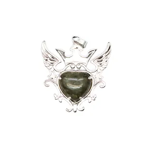 Detalle de colgante de corona y alas plateado con piedra natural en forma de corazón.