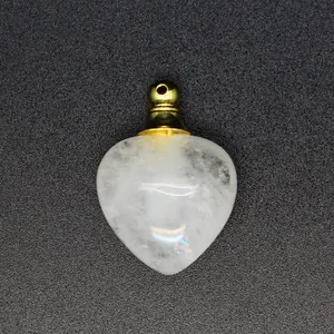 Primo piano di ciondolo diffusore in cristallo a forma di cuore dorato.