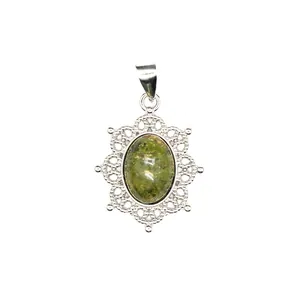 Close-up detail of an ornate silver hollow-out pendant with a green natural gemstone