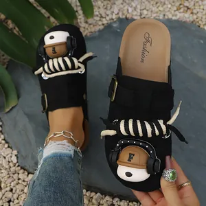 Macro view of black platform clogs featuring cute cartoon decor and thick rope laces