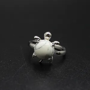 Detaillierte Makroansicht eines silbernen Schildkrötenrings mit weißem Marmorstein-Element.
