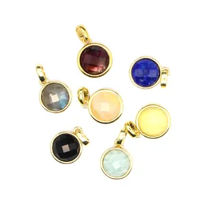 Macro shot of colorful faceted natural stone pendants with polished gold-plated metal frames
