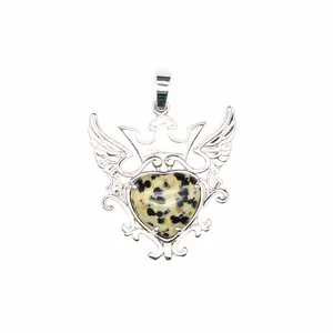 Detalle de un colgante de corazón de jaspe dalmata con diseño de corona y alas talladas