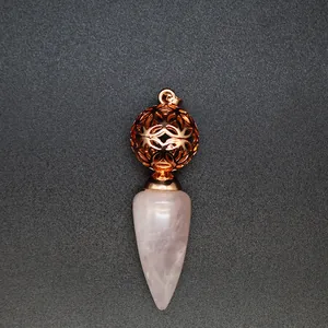 Dettaglio del ciondolo in quarzo rosa con una sfera filigranata cava in oro rosa
