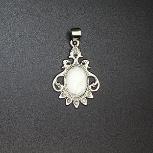 Macro detail of ornate silver pendant with marble-patterned white stone and crystal accents