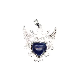 Detalle de colgante de corazón de piedra azul natural con corona y alas de plata
