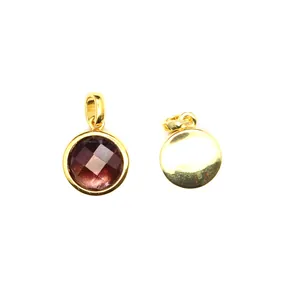 Detailed view of small round faceted garnet red stone pendant in gold frame