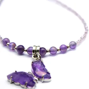 Detailed macro view showing the purple amethyst gemstone butterfly pendant on necklace