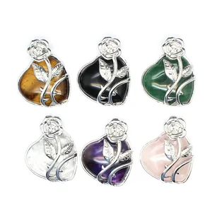 Vue détaillée de pendentifs cœur en pierre naturelle avec des motifs de rose en argent variés.