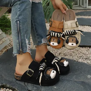 Detailed view of women's thick-soled clogs with decorative bear charms and rope