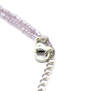 Close-up macro detail of silver lobster clasp and purple amethyst crystal beads on chain